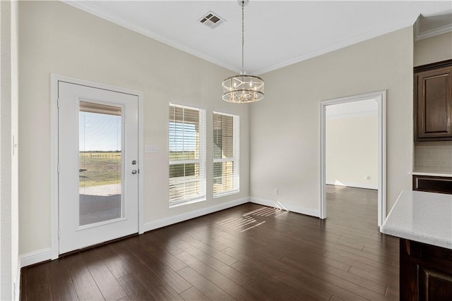 unfurnished dining area featuring a chandelier, dark hardwood / wood-style flooring, and ornamental molding