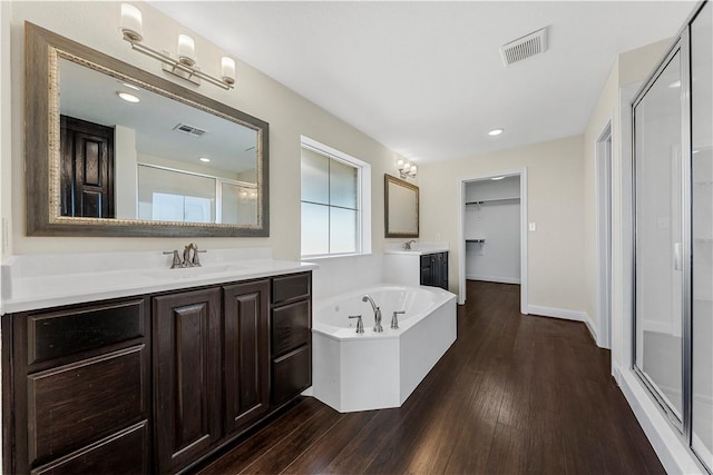 bathroom featuring vanity, wood-type flooring, and shower with separate bathtub