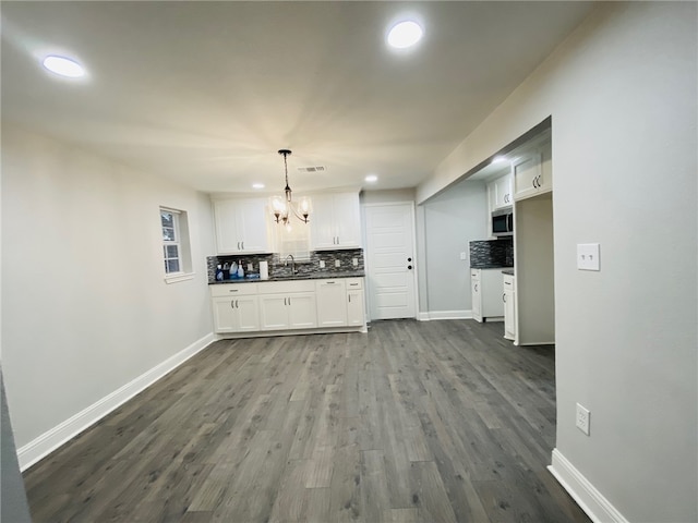 kitchen with pendant lighting, white cabinetry, sink, backsplash, and dark hardwood / wood-style floors