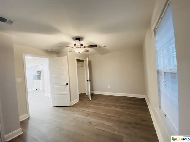 empty room featuring dark wood-type flooring and ceiling fan