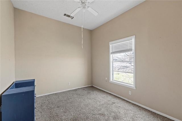 unfurnished room featuring baseboards, visible vents, a ceiling fan, a textured ceiling, and carpet flooring