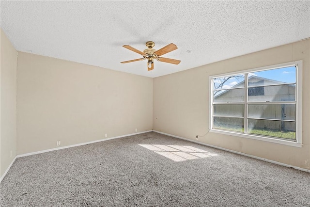 unfurnished room featuring carpet flooring, ceiling fan, a textured ceiling, and baseboards