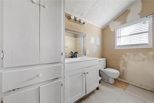 bathroom with lofted ceiling, toilet, a textured ceiling, vanity, and tile patterned flooring