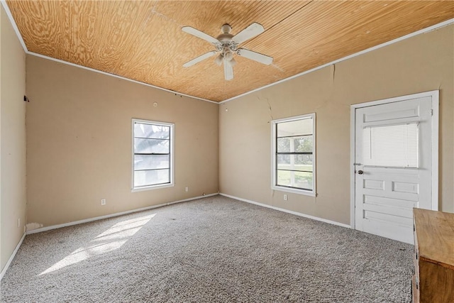 carpeted spare room featuring a ceiling fan, wooden ceiling, and plenty of natural light