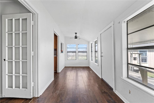 hall featuring lofted ceiling, baseboards, and dark wood finished floors