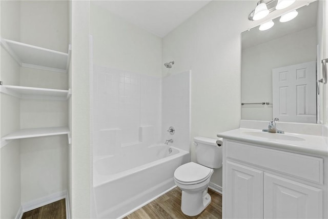 bathroom featuring vanity, bathing tub / shower combination, wood finished floors, and toilet