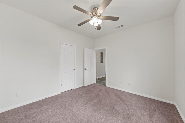 unfurnished room featuring a ceiling fan, carpet, visible vents, and baseboards