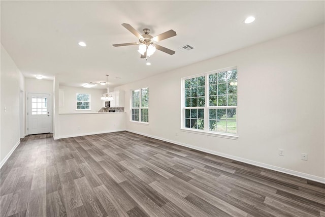 unfurnished living room featuring dark wood-style flooring, visible vents, and baseboards