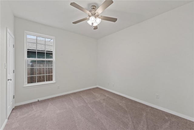 spare room featuring ceiling fan, carpet, and baseboards