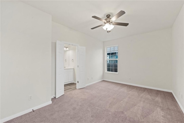 unfurnished bedroom with a ceiling fan, carpet flooring, connected bathroom, and baseboards