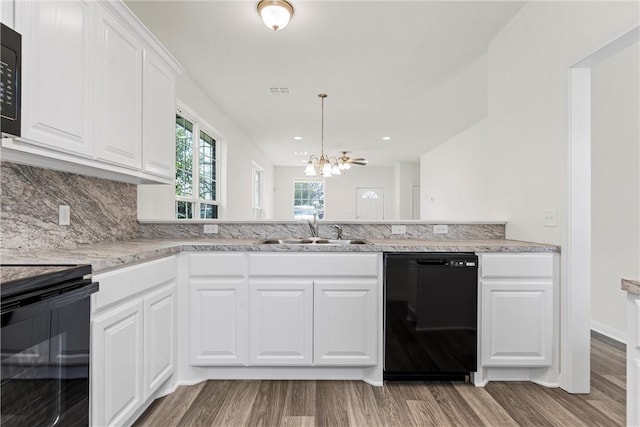 kitchen featuring a chandelier, wood finished floors, a sink, backsplash, and black appliances