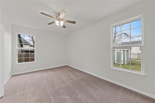 unfurnished room with carpet, a ceiling fan, and baseboards