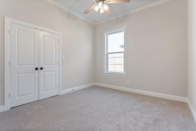 carpeted empty room featuring ceiling fan and ornamental molding