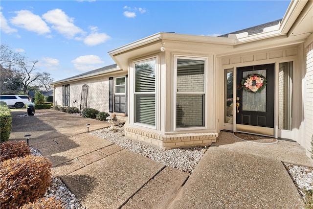 doorway to property featuring brick siding