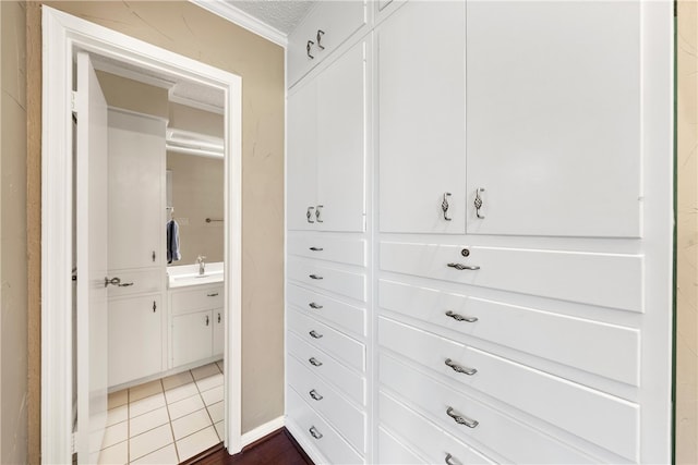 walk in closet featuring dark tile patterned floors and a sink