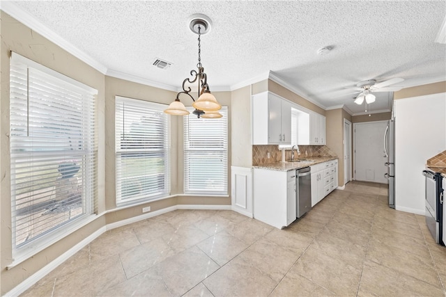 kitchen featuring a sink, visible vents, white cabinets, appliances with stainless steel finishes, and pendant lighting