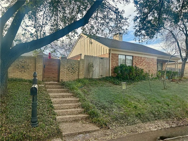 exterior space with brick siding and a chimney