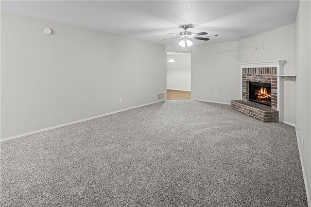 unfurnished living room with carpet, a fireplace, and ceiling fan