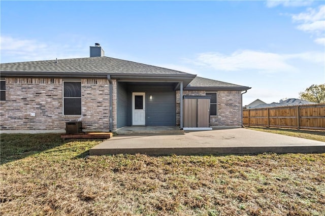 back of property featuring a lawn and a patio area