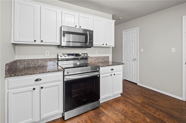 kitchen with white cabinets, stainless steel appliances, dark hardwood / wood-style floors, and dark stone counters