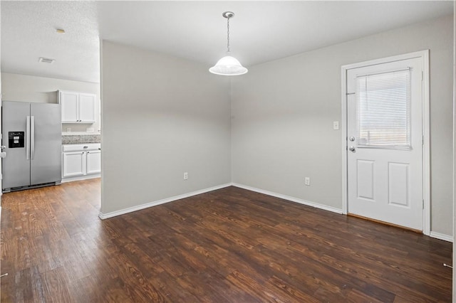 unfurnished dining area featuring dark hardwood / wood-style flooring