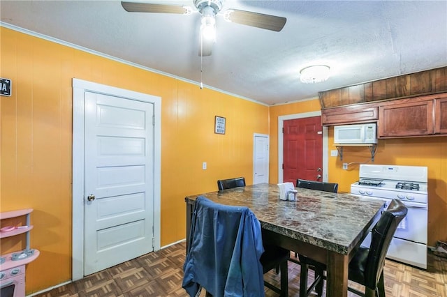 dining space featuring crown molding, ceiling fan, dark parquet flooring, and a textured ceiling