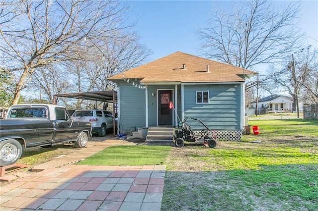 back of property featuring a carport and a yard