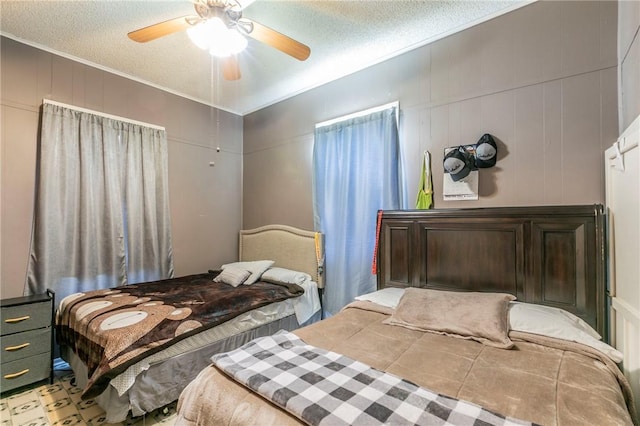 bedroom with ceiling fan, crown molding, and a textured ceiling