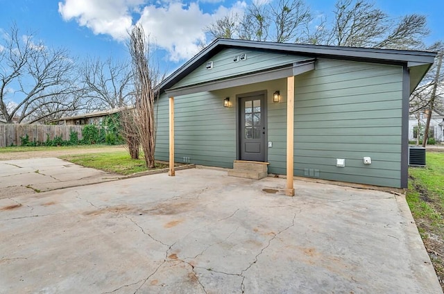 view of front of house with entry steps, a patio area, cooling unit, and fence