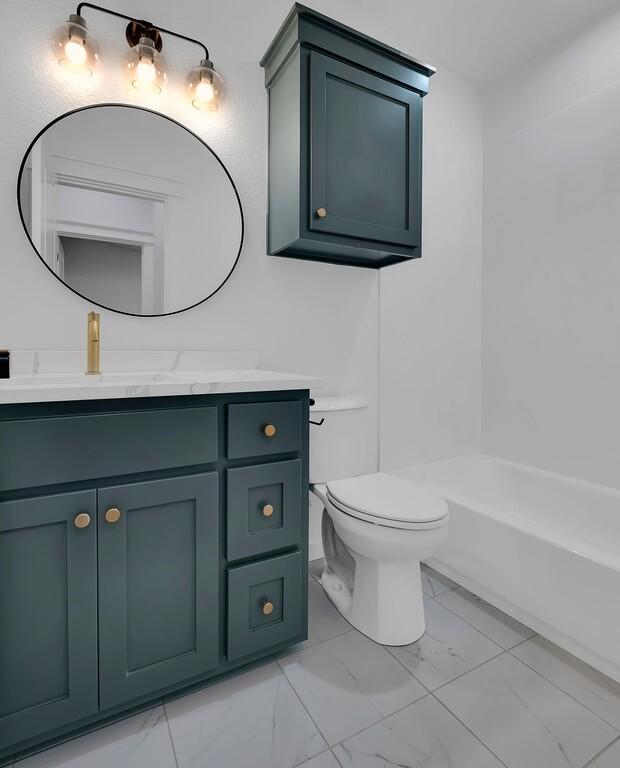 bathroom featuring toilet, marble finish floor, and vanity