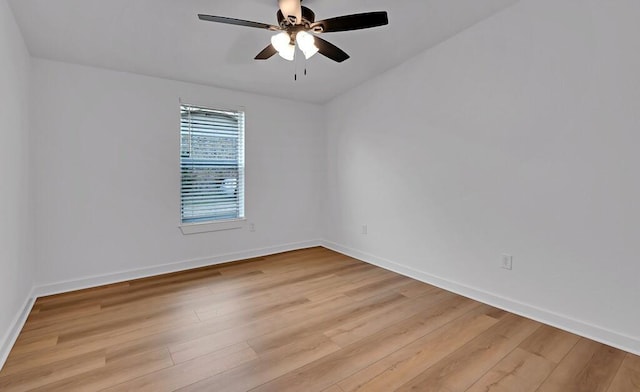 spare room with a ceiling fan, light wood-style floors, and baseboards