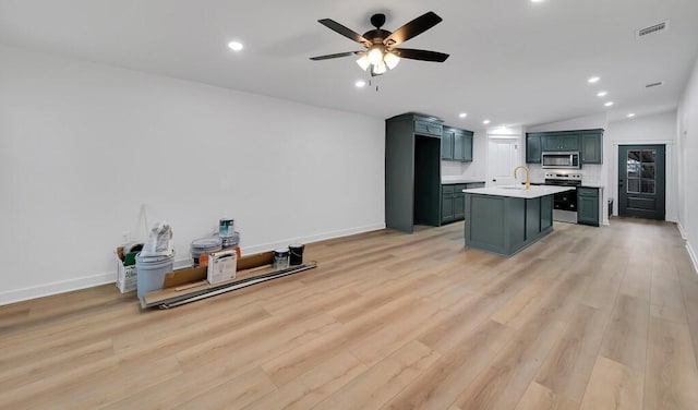 kitchen featuring visible vents, light wood-style flooring, a sink, stainless steel appliances, and light countertops