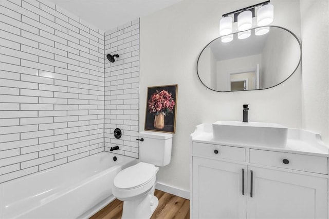 full bathroom with bathtub / shower combination, toilet, vanity, wood finished floors, and baseboards