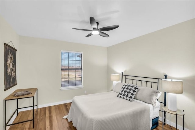 bedroom with ceiling fan, baseboards, and wood finished floors