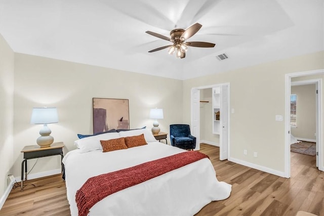 bedroom with baseboards, visible vents, a ceiling fan, and light wood-style floors