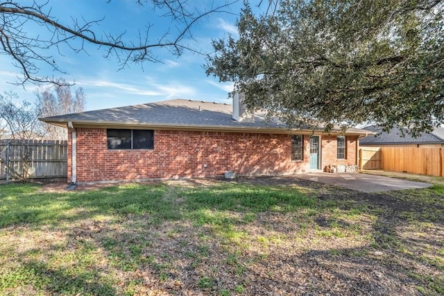 rear view of house with a patio area, a fenced backyard, a lawn, and brick siding