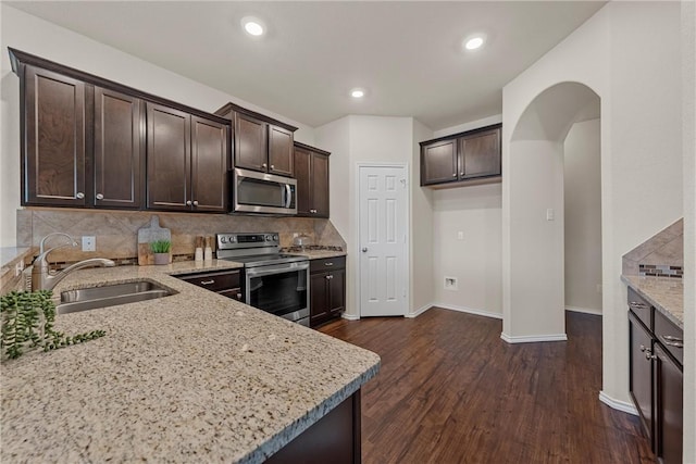 kitchen featuring sink, stainless steel appliances, and light stone countertops