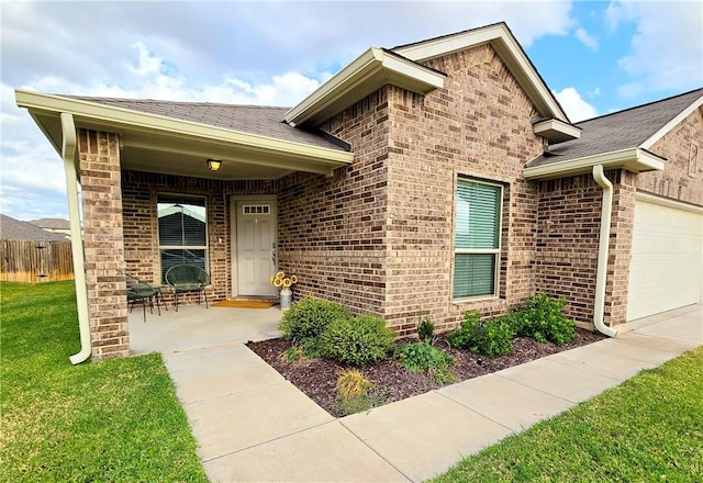 entrance to property with a garage and a lawn