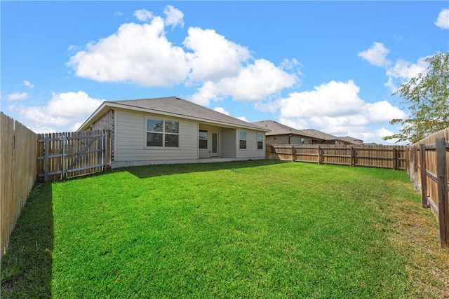 rear view of property with a yard