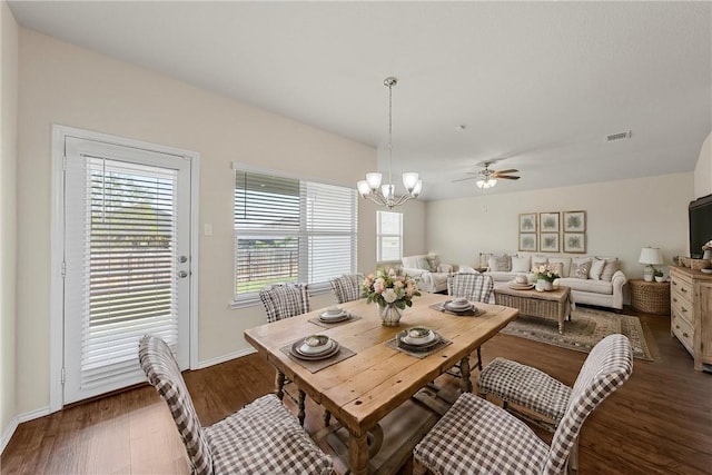 dining area with dark hardwood / wood-style flooring and ceiling fan with notable chandelier