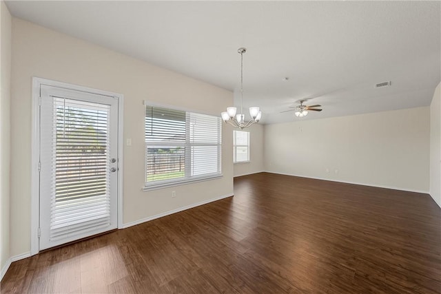 unfurnished dining area featuring ceiling fan with notable chandelier and dark wood-type flooring