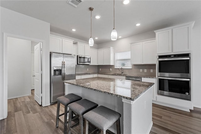 kitchen with white cabinets, appliances with stainless steel finishes, and a kitchen island