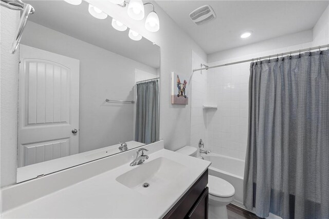 full bathroom featuring shower / bath combo, vanity, and toilet