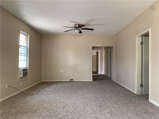 spare room featuring carpet flooring, ceiling fan, cooling unit, and a textured ceiling