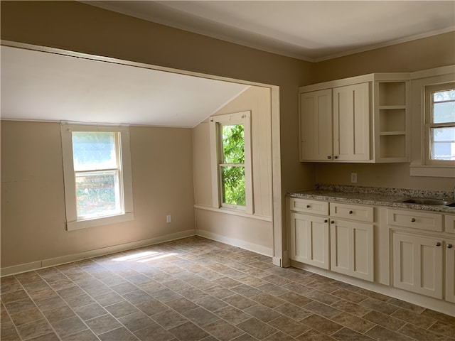 kitchen featuring light stone countertops, a wealth of natural light, and sink