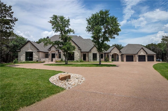 french country style house with a garage and a front lawn