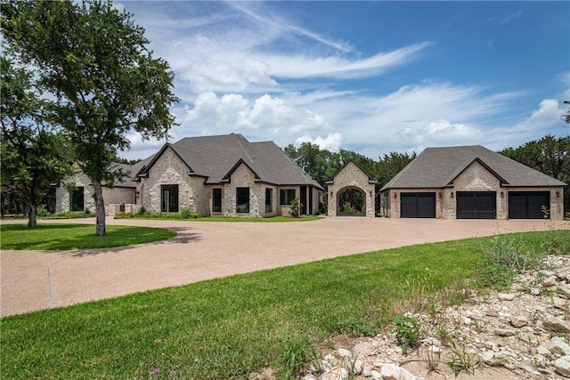 french provincial home featuring a garage and a front yard