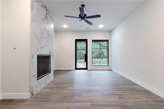 unfurnished living room featuring ceiling fan and a high end fireplace