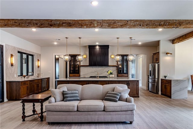 living room with beam ceiling, sink, and light hardwood / wood-style flooring