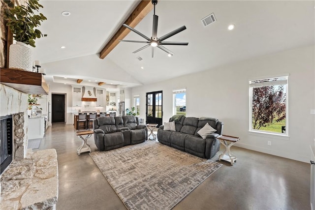 living room with vaulted ceiling with beams, a premium fireplace, plenty of natural light, and ceiling fan